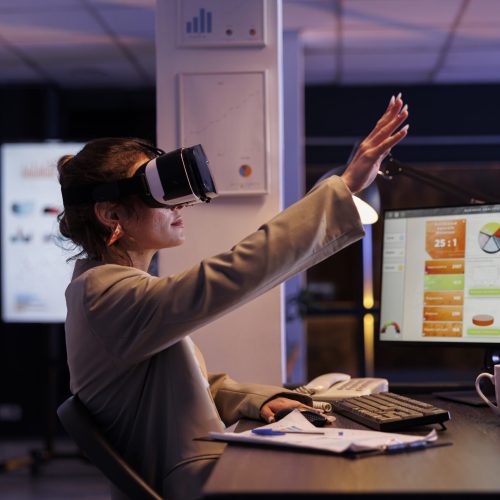 Executive manager wearing virtual reality headset, analyzing financial growth report using hologram in startup office. Businesswoman working late at night at company startegy. Technology concept